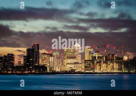 Die Türme von Canary Wharf in der Ferne mit der Themse im Vordergrund nach Sonnenuntergang, London, Vereinigtes Königreich, Januar 2018 Stockfoto