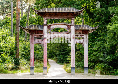 Die alten hölzernen chinesische Tor in den Garten von tropischen Agronomie in Paris hat seine ursprüngliche Farbe Rot wegen der Einwirkung von Sonnenlicht und Regen verloren. Stockfoto