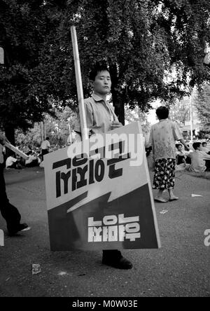 Nordkoreanische Mann, der einen Propaganda Billboards in der Straße, Pyongan Provinz, Pyongyang, Nordkorea Stockfoto