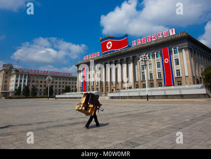 Nordkoreanische Mann, der einen Schreibtisch aus Holz auf seinem Rücken in Kim Il Sung Platz, Pyongan Provinz, Pyongyang, Nordkorea Stockfoto