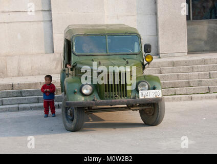 Nordkoreanische Junge in der Nähe einer alten nordkoreanischen Armee Jeep,Hwanghae Province, Kaesong, Nordkorea Stockfoto