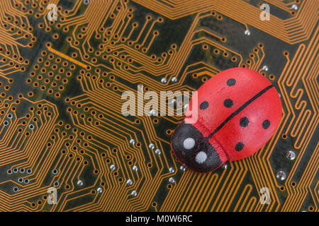 Kleines Spielzeug Marienkäfer - als visuelle Metapher für das Konzept der Computer bugs, Bugs, Bugs, Viren. Stockfoto