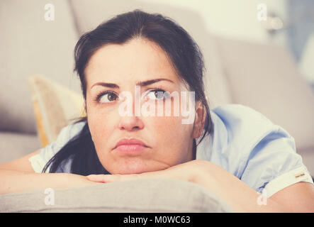 Düstere erwachsene Frau Depression zu Hause auf dem bequemen Sofa Stockfoto