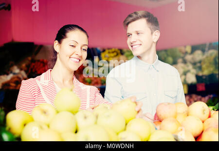 Positive junges paar Sie Obst und Gemüse auf dem Markt Stockfoto