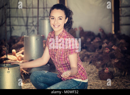Fröhliche Frau Bauer Hühner innerhalb von Coop einziehen Stockfoto