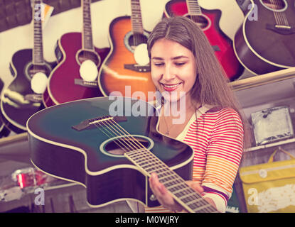 Porträt der jungen Kunden den Kauf neuer Gitarre im Store und lächelnd Stockfoto