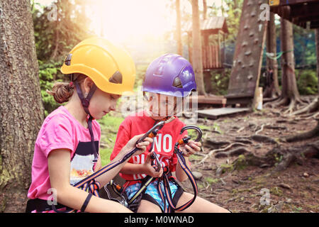 Freunde erfahren Sie im Hochseilgarten zu klettern Stockfoto