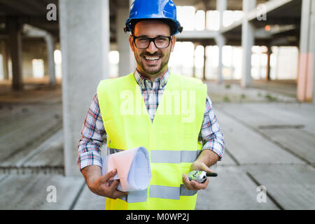 Männliche Architekt mit Blueprints mit walkie-talkie Stockfoto