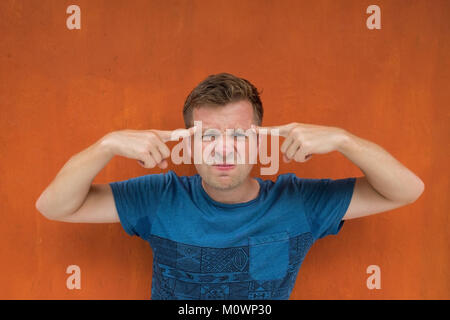 Portrait betonte Mann mit Zeigefinger gun Geste in der Nähe vom Kopf auf rotem Hintergrund. Negative menschliche Emotion Stockfoto