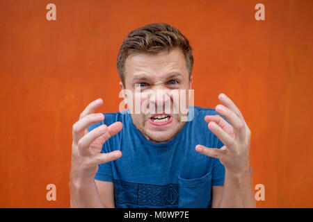 Verzweifelte Wut tobte Mann im blauen Hemd schreien, laut dem die Augen voller Zorn. Crazy bösen Freund schreien auf seine Freundin Stockfoto