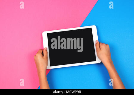 Kid Hände mit Tablet-PC auf rosa Hintergrund. Stockfoto
