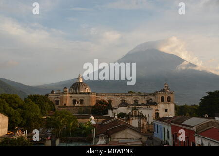 Blick auf Vulkan Fuego hinter Kirche Nuestro Senora de la Merced in Antigua, Guatemala Stockfoto