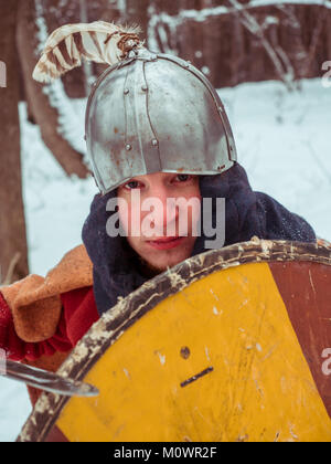 Fränkischer Krieger im historischen Kostüm mit Schwert, Schild, Helm im Winter Wald Stockfoto