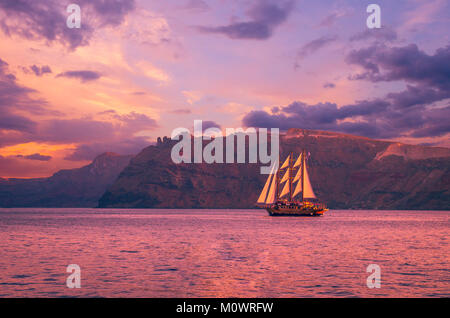 Segelboot in Santorini, Griechenland. Segelschiff in der Nähe einer Insel Kykladen navigieren. Das Foto ist bei Sonnenuntergang aufgenommen. Stockfoto