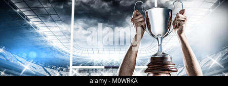 Zusammengesetztes Bild von erfolgreicher Rugbyspieler holding trophy Stockfoto