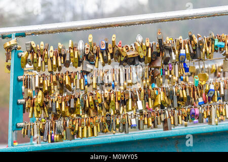 Sammlung von Vorhängeschlösser auf einem Fuß Brücke über Fluss Wye gesperrt an einem regnerischen Winter an der Stadt von Bakewell im Peak District, Derbyshire, Engl Stockfoto