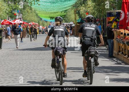 Kanada, in der Provinz Quebec, Montreal, das Dorf Nachbarschaft, Gay Viertel der Stadt, St. Catherine Street, der Regenbogen Bälle der LGBT-Flagge eine Arbeit von Claude Cormier und ordnet die Straße, Fahrrad Polizist und Frau Stockfoto