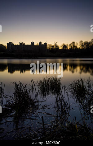 Framlingham Schloss in Suffolk bei Sonnenaufgang auf dem Wasser spiegelt Stockfoto