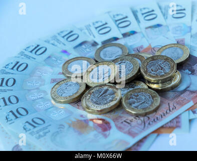 Mehrere neue britische Pfund Münzen zufällig liegen auf einem Schwärmten aus, Bett von neuen Polymer zehn Pfund Sterling Notizen Stockfoto