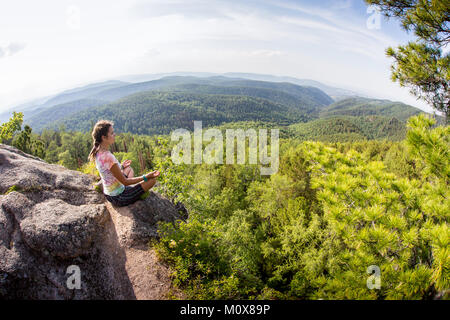 Junge Frau sitzen yoga meditation am Berg rock Stockfoto