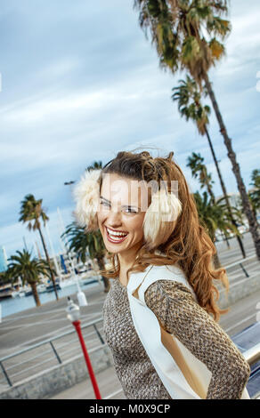 in Barcelona für einen perfekten Winter. lächelnde Frau trendige Tourist in Ohrenschützer in Barcelona, Spanien Stockfoto