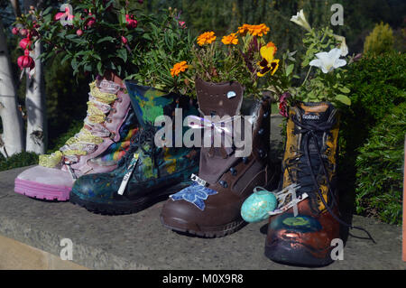 Alten bunten Schuhe recycelt in Pflanzmaschinen auf einer Wand an, RHS Garden Harlow Carr, Harrogate, Yorkshire. UK. Stockfoto