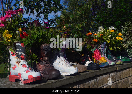 Alten bunten Schuhe recycelt in Pflanzmaschinen auf einer Wand an, RHS Garden Harlow Carr, Harrogate, Yorkshire. UK. Stockfoto