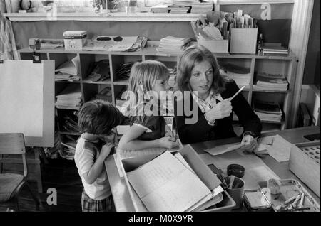 Dorf Grundschule 70er Jahre England. Cheveley Cambridgeshire 1978 Großbritannien. Schulkinder kommen zum Lehrer-Schreibtisch vor dem Klassenzimmer und bekommen Anweisungen. HOMER SYKES Stockfoto