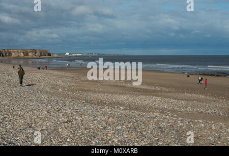 Der Strand von Seaham blickt nach Norden mit der Stadt Sunderland im fernen Hintergrund und nur wenige Menschen am Strand Stockfoto