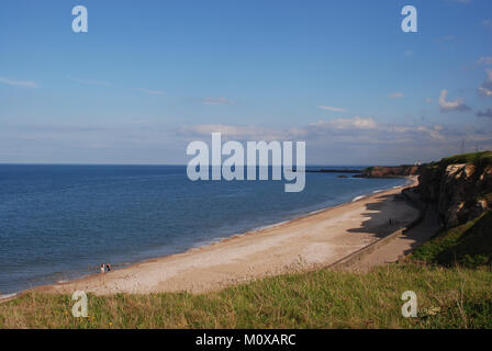 Der Strand von Seaham blickt an einem klaren Tag nach Süden zum Hafen und bietet einen Strand mit Klippen und einen Pier mit Leuchtturm Stockfoto