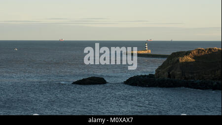 Pier- und Hafeneingang in Seaham mit Featherbed Rocks im Vordergrund und Versand auf See Stockfoto