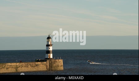 Kleines Boot, das Seaham Harbour verlässt, um Meer zu angeln, wobei der alte Leuchtturm gut zu sehen ist Stockfoto