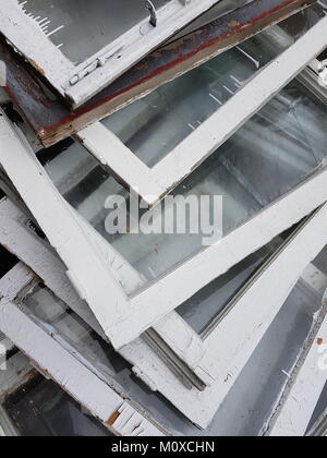 Ändern von Fensterrahmen: Entfernt alte vintage Holzfenster mit weißer Farbe liegen auf dem Heap abgedeckt. Stockfoto