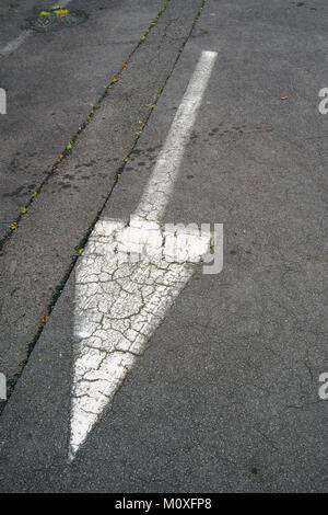 Weißer Pfeil Symbol auf schwarzem Asphalt Stockfoto
