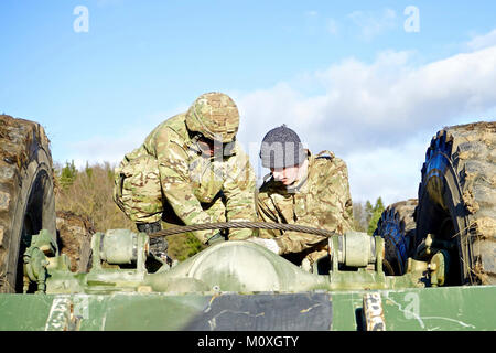 (Von links nach rechts) Sgt. Antoinne Adams, ein taktischer Power Generation Specialist, Sitz Supply Company, 615th Aviation Support Battalion, 1 Air Cavalry Brigade, 1.Kavallerie Division und Handwerker Scott Burns, ein Recovery mechanic mit der britischen Recovery Platoon, 5. gepanzerte Unternehmen, 3. Royal Electrical Mechanical Engineers Bataillon, arbeiten zusammen, um einen Schraubenschlüssel, um die Wiederherstellung des Fahrzeugs während der Ausbildung innerhalb des Hohenfels Training Bereich in Deutschland zu einem umgestürzten Fahrzeug zu sichern, Jan. 19, 2018. Die Wiederherstellung des Fahrzeugs Teams ausgebildet für Verbündete Geist VIII, eine Übung zu verbessern vorbereiten Stockfoto