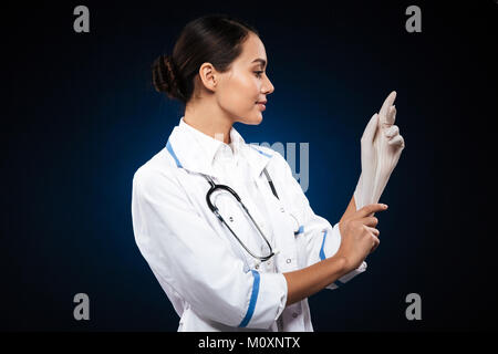 Zuversichtlich lächelnd weibliche Arzt tragen weiße medizinische Handschuhe in Schwarz isoliert Stockfoto