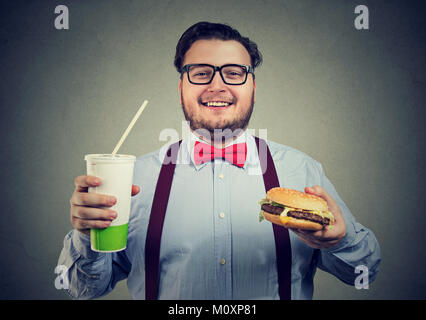 Junge Glücklich, aufgeregt, während mit Burger und Soda an der Kamera schaut. Stockfoto