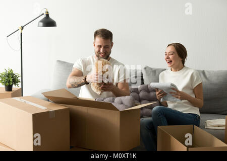Lachen junges Paar, das Spaß, die Kisten packen, im neuen Haus Stockfoto