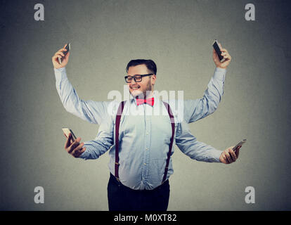 Chunky junger Mann in formelle Kleidung in vier Arme und mit Smartphones, Multitasking. Stockfoto