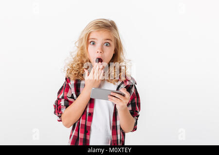 Porträt einer schockiert kleines Mädchen mit Handy und Kamera auf weißem Hintergrund Stockfoto