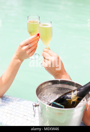 Paar mit Champagner Gläser in den Pool. Nahaufnahme Stockfoto