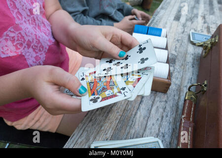 Sieht aus wie ein Paar Buben in einer Poker Hand eines jungen Mädchens mit Türkis lackierte Nägel. Clitherall Minnesota MN USA Stockfoto