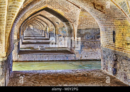 Bogenförmige Gewölbe aus Backstein, die unter einem alten Stein Allahverdi Khan Brücke, Isfahan, Iran. Stockfoto