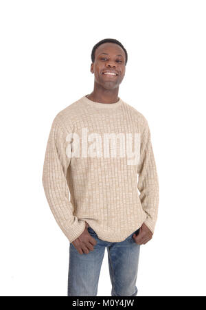 Eine junge glücklich afrikanische amerikanische Mann in einem beige Pullover und Jeans auf weißem Hintergrund lächelnd Stockfoto