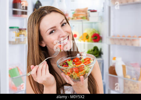 Portrait der junge lächelnde Frau das Essen von frischem gesunden Salat Stockfoto