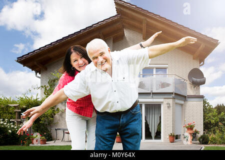 Portrait von Happy Senior Paar außerhalb des Hauses stehend Stockfoto