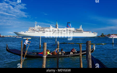 Riesiges Kreuzfahrtschiff innerhalb der venezianischen Lagune gegen einen kleinen traditionellen Gondel. Ein großes Problem für die Erhaltung von Venedig fragilen Umwelt und Stockfoto