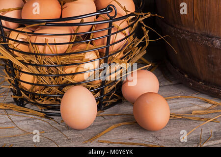 Braun Huhn Eier in einen Korb und ein rustikales Holz- Oberfläche Stockfoto