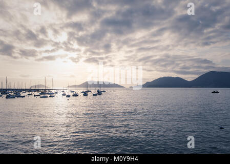 Ruhe mediterranen italienischen Meerblick von kleinen Hafen mit mehreren Booten, in der Ferne und die Berge im Hintergrund bei Sonnenuntergang. Vintage Retro, matt Stockfoto