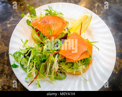 Geräucherter Lachs und Avocado Sandwich auf Vollkornbrot mit Rucola garnieren Stockfoto